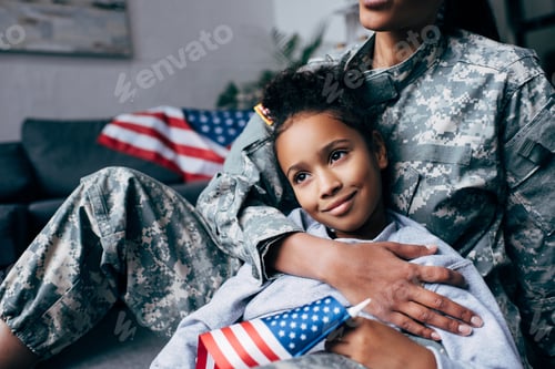 Preview: cropped view of african american daughter and female soldier in military uniform with american flag