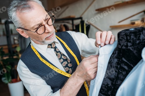 Preview: handsome tailor measuring shirt at sewing workshop