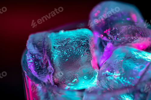 Preview: Close up of ice cubes in glass of alcoholic cocktail, beverage, drink in multicolored neon light