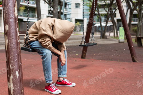 Preview: Lonely teenager swinging alone outdoors