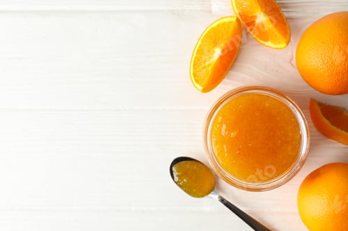 Preview: Oranges, spoon and glass jar with jam on white wooden background