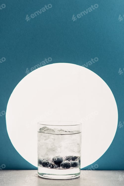 Preview: fresh gin and tonic in glass on blue background with back light