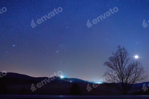 Preview: Night outdoor scene with moon and huge numbers of stars above range of moutains