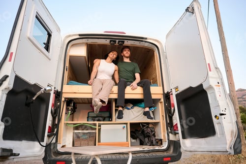 Preview: Couple relaxing in converted van enjoying camper van life