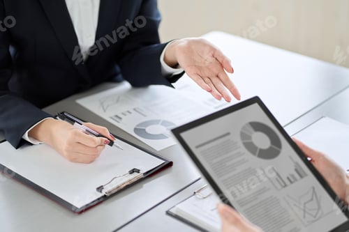 Preview: Asian business woman showing and explaining a tablet
