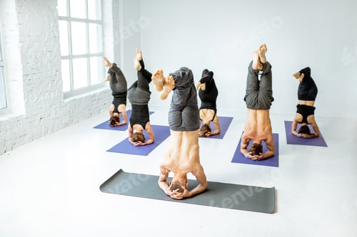 Preview: Group of people practising yoga indoors