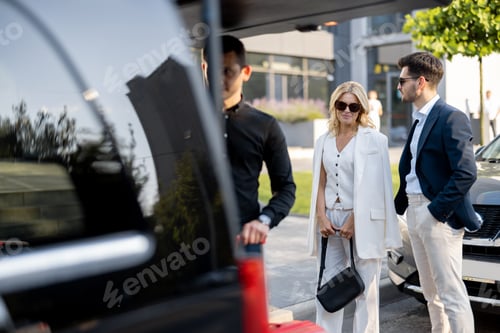 Preview: Business couple near minivan taxi with a suitcases and chauffeur