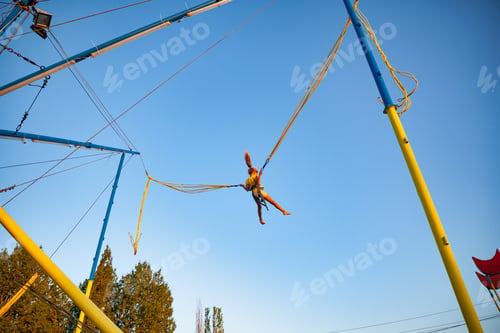 Preview: Little girl flies on elastic bands and jumps on a trampoline