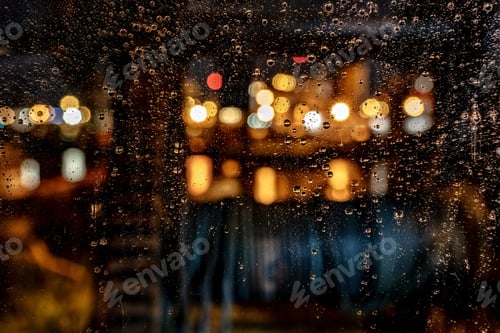 Preview: Beautiful shot of water drops on a window during a rainy night with a blurred background