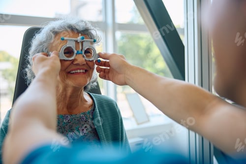 Preview: Happy senior woman checking her vision at ophthalmological clinic.