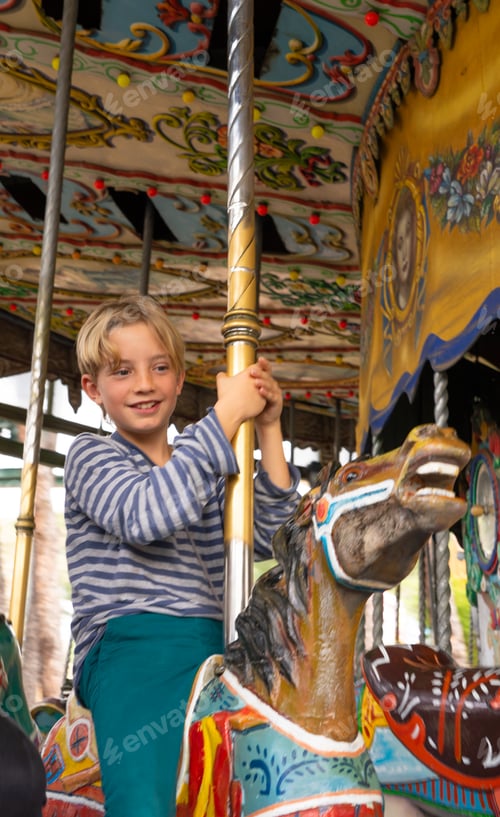 Preview: Boy enjoying on a merry-go-round at an amusement park