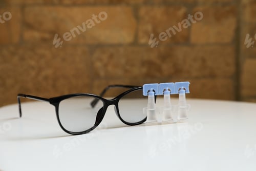 Preview: Single dose eye drops and glasses on white table