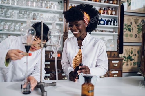 Preview: Multiracial pharmacists are standing in a vintage pharmacy and working on an experiment together.