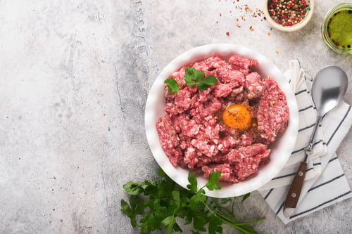 Preview: Raw minced meat. Ground meat beef, pork or lamb spices, herbs and eggs on white plate on light grey