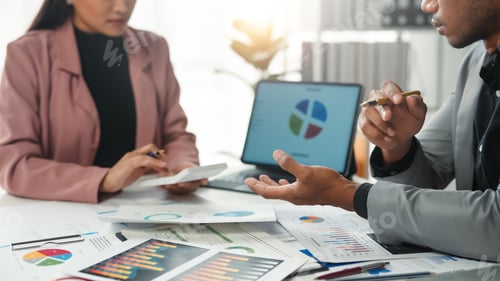 Preview: Business team analyzing financial graphs and charts on desk