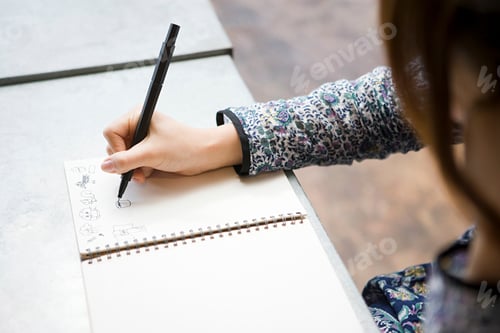 Preview: Creative hand at work sketching in a notebook
