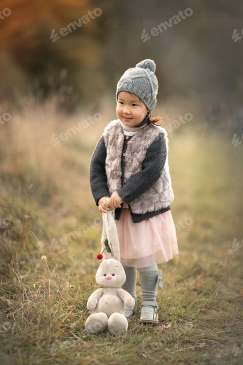Preview: happy child girl play with toy in nature