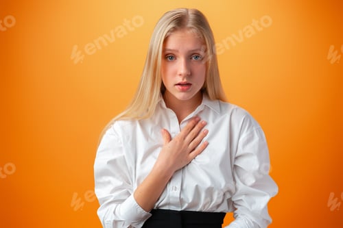 Preview: Shocked joyful teen girl against orange background