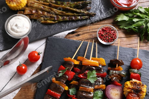 Preview: Skewers with tasty grilled vegetables served on wooden table, flat lay