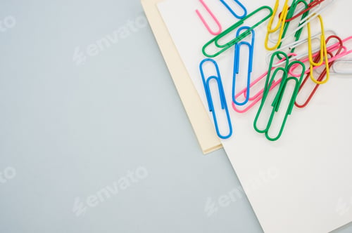 Preview: Closeup shot of a blank paper with colorful paper clips on a light green background