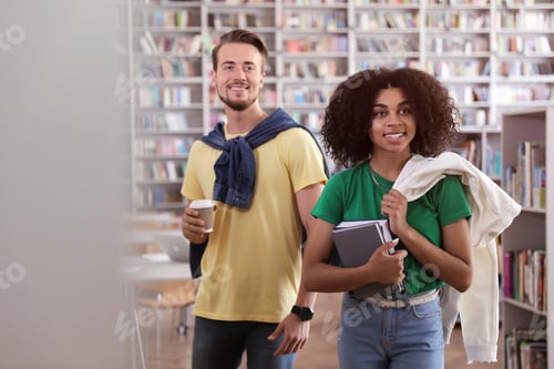 Preview: Happy young people with books in library