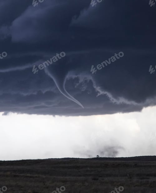 Preview: Tornado forming under dark storm clouds over plain