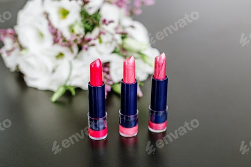 Preview: Set of colored lipsticks. Concept of cosmetics and care. Beautiful flowers. Copy space.