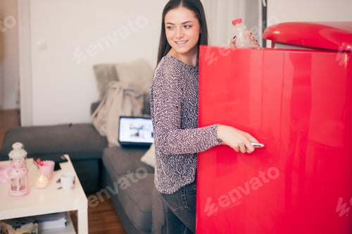 Preview: Beautiful Smiling One Young Woman, Opening Fridge In Her Apartment.