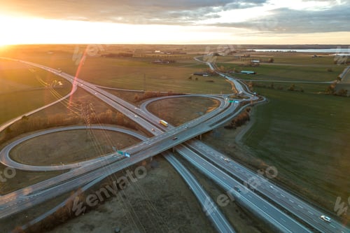 Preview: Aerial view of modern highway road intersection at dawn on raising sun