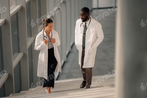 Preview: Doctors walking and discussing on hospital stairs