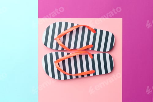 Preview: Flip flops sit on a colorful background of pink and blue in a simple arrangement