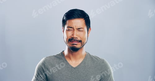Preview: Sad, Asian man and crying emotions in studio for mourning loss, broken heart and bad news. Person,