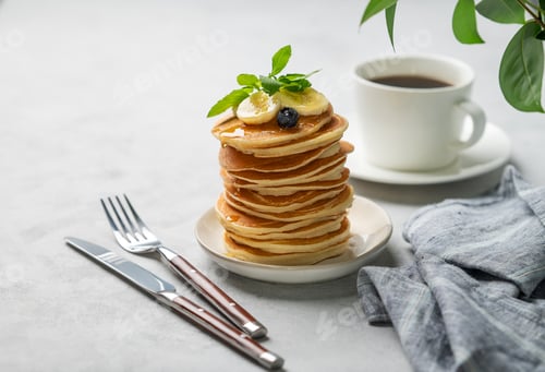 Preview: A stack of oat banana pancakes with fresh fruit slices, berries and honey on a light background