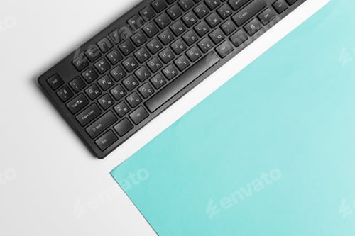 Preview: Computer keyboard on a turquoise paper background