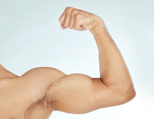 Preview: Dont mess with him. Shot of a man flexing his biceps against a studio background.