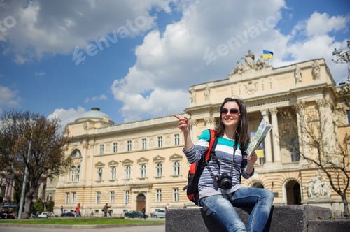 Preview: Young female tourist with map and camera