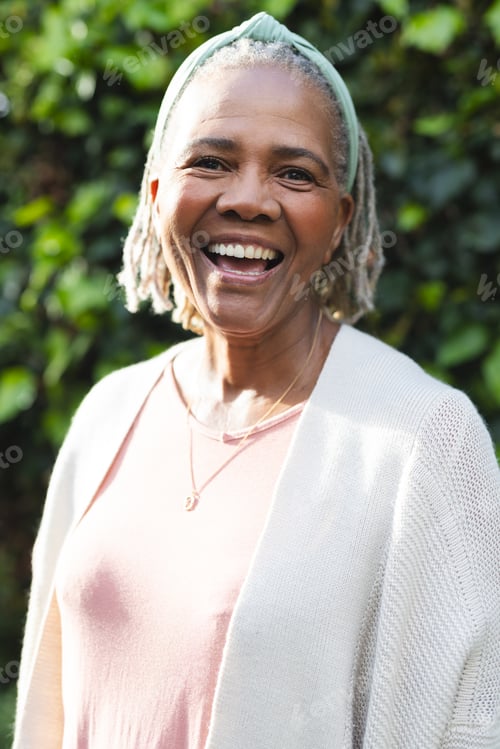 Preview: Portrait of happy senior african american woman standing in garden