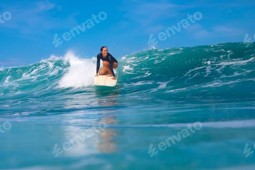 Preview: Female surfer on a blue wave