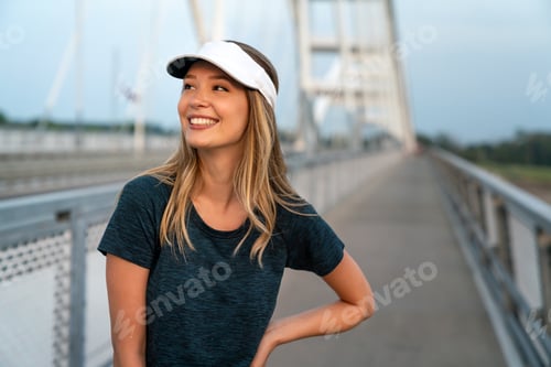 Preview: YYoung smiling satisfied fit woman resting after an active fitness training outdoors in city
