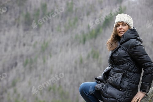 Preview: A woman outside in nature takes in the view of beautiful, snow covered mountains