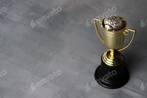 Preview: Brain inside gold cup trophy with copy space.