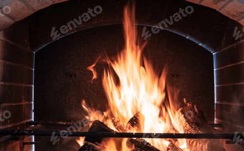 Preview: Fire orange tongues on black background in a brick fireplace
