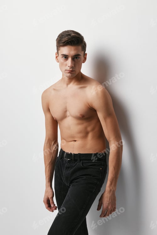 Preview: A man with a naked torso and in trousers on a light background
