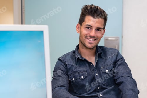 Preview: Smiling young handsome man in office