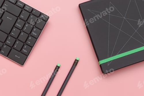 Preview: Top view, notebook and pencil with keyboard on pink background. Close-up