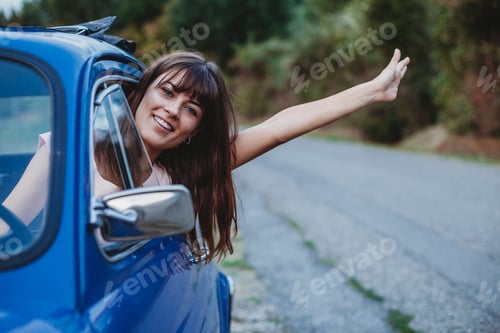 Preview: Woman driving, sticking head and arm out of car window