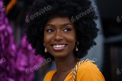 Preview: Photo of a stylish young black woman with curly hair wearing orange crop top walking in the street