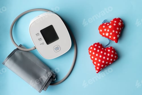Preview: Automatic blood pressure monitor and two soft red hearts. Medical electronic tonometer