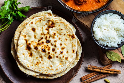 Preview: Chapati bread on wooden plate, top view, close up. Indian cuisine concept.