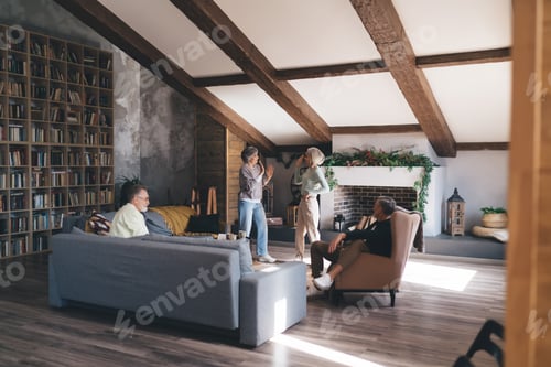 Preview: Group of senior friends having fun in living room at home